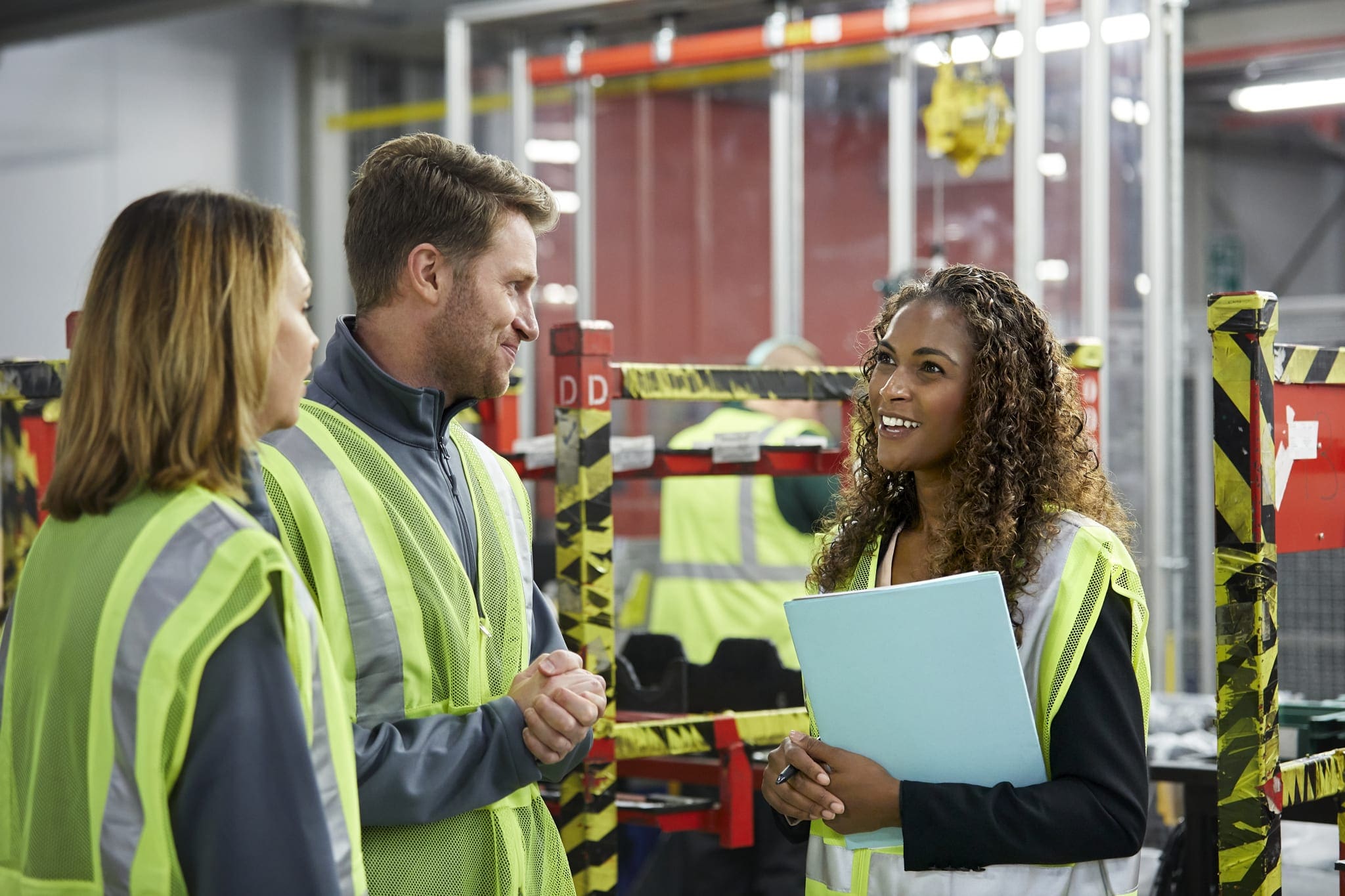 Manager talking to engineers in car plant